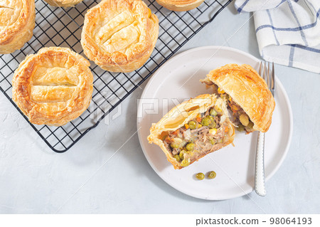 Sliced beef pot pie on plate, pies on cooling rack, horizontal, top view Sliced beef pot pie on plate, pies on cooling rack, horizontal, top view 98064193
