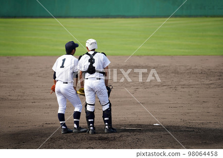 Pitcher and catcher talking on the mound 98064458