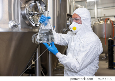 Brewer overseeing the beer production process in the factory 98065200