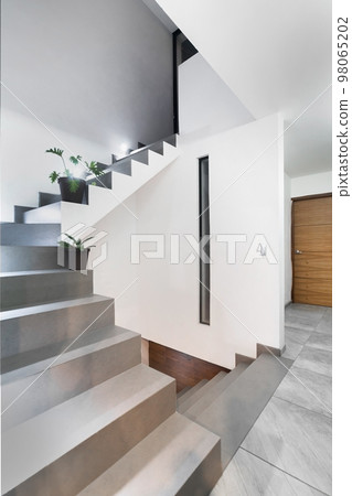 facade of a modern house with stone, staple that wraps the windows painted in gray, metal entrance, ironwork facade of a modern house with stone, staple that wraps the windows painted in gray, metal entrance, ironwork 98065202