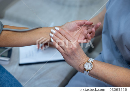 Close up picture of doctors palping patients pulse Close up picture of doctors palping patients pulse 98065336