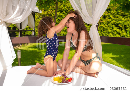 Cute family having fun in the recreation zone in a swimming pool Cute family having fun in the recreation zone in a swimming pool 98065381