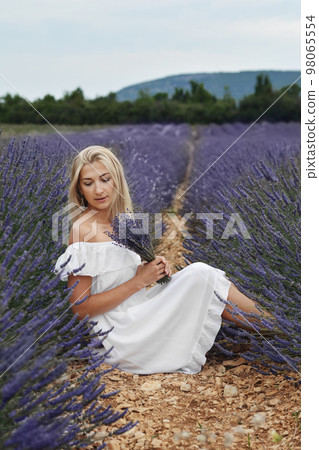 Beautiful woman in a white dress on a lavender field in Provence Beautiful woman in a white dress on a lavender field in Provence 98065554