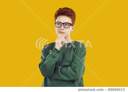 Thoughtful teenage boy standing with his hand on chin 98066015