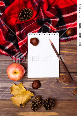 Autumn still life - notebook, pencil, blanket and gifts of autumn on a wooden background. Top view Autumn still life - notebook, pencil, blanket and gifts of autumn on a wooden background. Top view 98066305