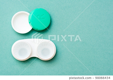 In an open container are lenses in a liquid for cleaning. Top view. Copy space 98066434