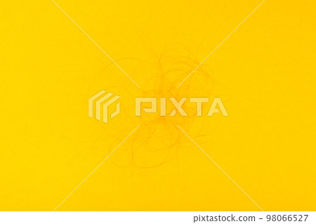 Horn of fallen hair on a yellow background. Concept - hair loss. Top View Horn of fallen hair on a yellow background. Concept - hair loss. Top View 98066527