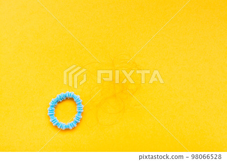 Band for hair and hanks of fallen hair on a yellow background. Concept - hair loss. Top View 98066528