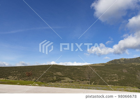 Mountains. Green mountains in the municipality of El Atazar, north of the Community of Madrid. Sunny day with air and clouds decorating the sky. Iron decoration on the green grass. Farmer. Donkey. Mountains. Green mountains in the municipality of El Atazar, north of the Community of Madrid. Sunny day with air and clouds decorating the sky. Iron decoration on the green grass. Farmer. Donkey. 98066678