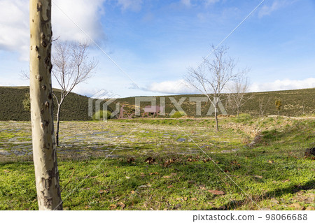 Mountains. Green mountains in the municipality of El Atazar, north of the Community of Madrid. Sunny day with air and clouds decorating the sky. Iron decoration on the green grass. Farmer. Donkey. 98066688