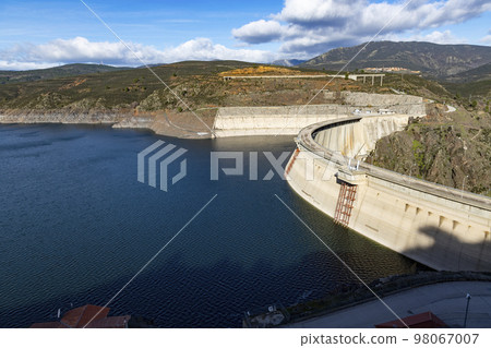 Reservoir. Prey. Dam located in the Atazar, north of the Community of Madrid. Damned water next to some green and pink mountains. Horizontal Photography Reservoir. Prey. Dam located in the Atazar, north of the Community of Madrid. Damned water next to some green and pink mountains. Horizontal Photography 98067007