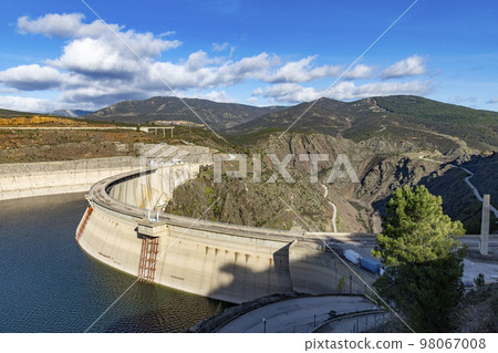 Reservoir. Prey. Dam located in the Atazar, north of the Community of Madrid. Damned water next to some green and pink mountains. Horizontal Photography Reservoir. Prey. Dam located in the Atazar, north of the Community of Madrid. Damned water next to some green and pink mountains. Horizontal Photography 98067008
