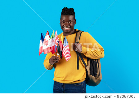 Study Abroad. Happy Black Man Holding Stack Of International Flags And Backpack Study Abroad. Happy Black Man Holding Stack Of International Flags And Backpack 98067305
