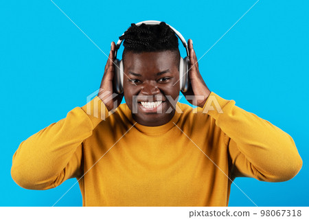 Happy Young African American Man Listening Music In Wireless Headphones Happy Young African American Man Listening Music In Wireless Headphones 98067318