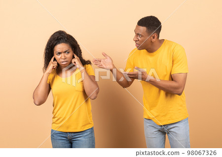 Conflict, family relationship problems. Angry black man screaming at wife, mad woman covering ears with hands 98067326