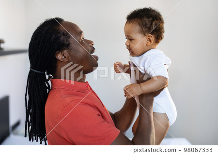 Portrait Of Young Black Father Chatting With Cute Little Baby At Home 98067333