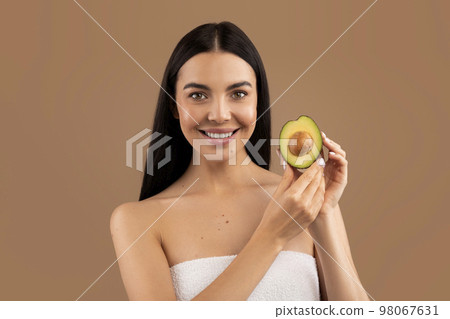 Beautiful half-naked young woman holding avocado in her hand 98067631