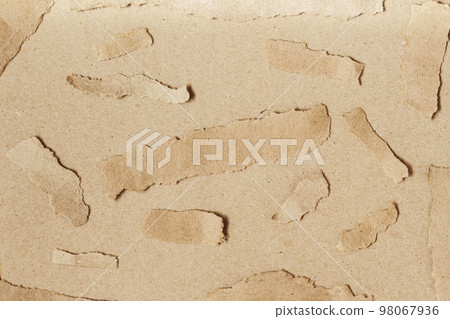 Ripped pieces craft paper on natural brown cardboard background. Texture Ripped pieces craft paper on natural brown cardboard background. Texture 98067936