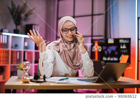 Young woman having phone call with partners at evening time, working process at office. Young woman having phone call with partners at evening time, working process at office. 98068612