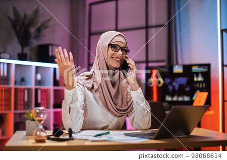 Young woman having phone call with partners at evening time, working process at office. Young woman having phone call with partners at evening time, working process at office. 98068614