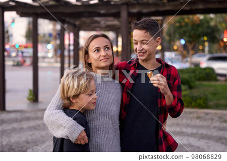 Family in a summer park. Mother and her sons with ice cream in the city. 98068829