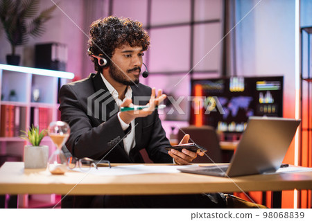 Confident young man at evening time, working process at office. Confident young man at evening time, working process at office. 98068839