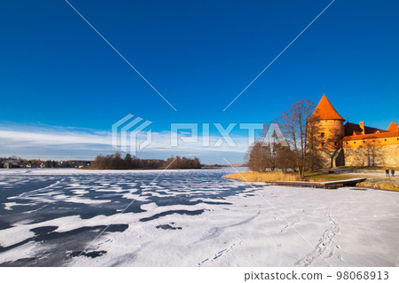 Trakai, Lithuania - 01 08 22: Island Castle in winter in sunny weather, lake covered with ice Trakai, Lithuania - 01 08 22: Island Castle in winter in sunny weather, lake covered with ice 98068913