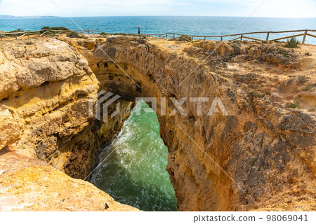Natural caves and beach, Algarve Portugal. Rock cliff arches of Seven Hanging Valleys and turquoise sea water on coast of Portugal in Algarve region 98069041