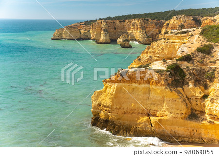 Natural caves and beach, Algarve Portugal. Rock cliff arches of Seven Hanging Valleys and turquoise sea water on coast of Portugal in Algarve region 98069055
