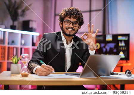 Portrait of attractive confident bearded IT specialist, office manager, wearing suit using laptop Portrait of attractive confident bearded IT specialist, office manager, wearing suit using laptop 98069234