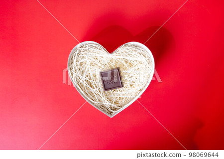紅色背景心形容器中的巧克力 紅色背景心形容器中的巧克力 98069644