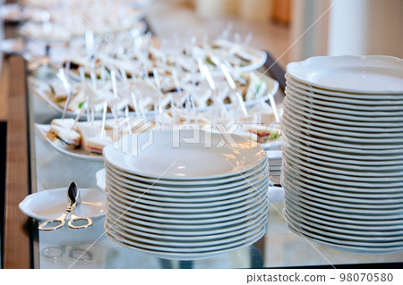 a stack of white plates on banquet table a stack of white plates on banquet table 98070580