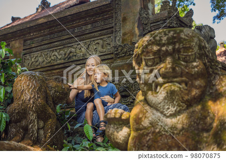 Mom and son travelers discovering Ubud forest in Monkey forest, Bali Indonesia. Traveling with children concept 98070875