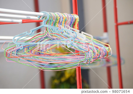 cloth hanger multi colored - colorful old plastic aluminum clothes hanger on the clothesline 98071654