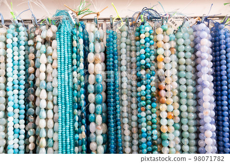 Beads from various gemstones on the showcase of jewelry store 98071782