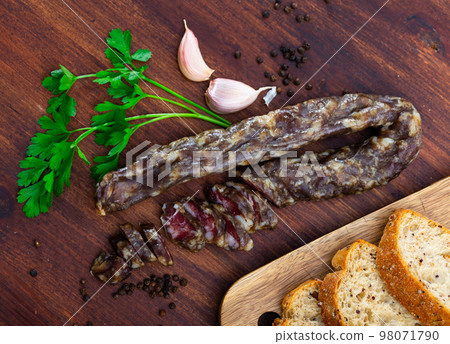 Dried pork meat sausage served on wooden table 98071790