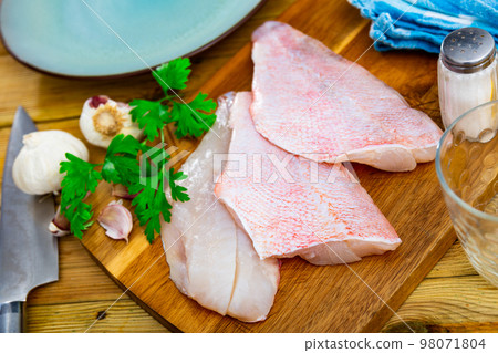Unprepared chicken fillets on kitchen table Unprepared chicken fillets on kitchen table 98071804