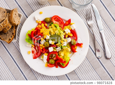 Salad with cheese, pesto sauce, lettuce, tomatoes and olives 98071828