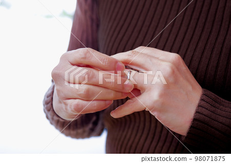 Woman removing a ring Woman removing a ring 98071875