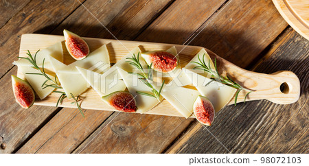 Cheese plate - cheeses and figs on wooden background Cheese plate - cheeses and figs on wooden background 98072103