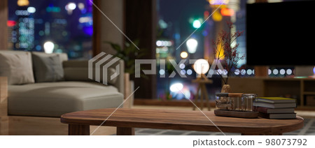 Copy space on wood coffee table in modern contemporary apartment living room at night 98073792