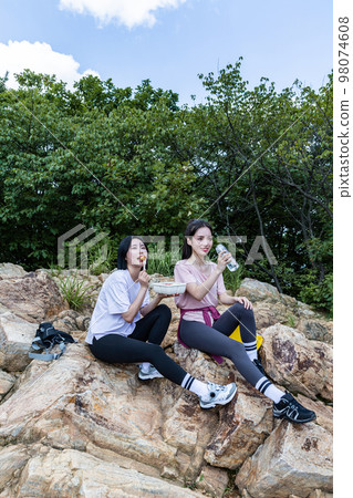 korean young women hiking and plogging_eating water and lunch box 98074608