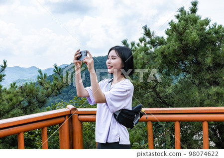 korean young women hiking and plogging_taking a picture landscape korean young women hiking and plogging_taking a picture landscape 98074622