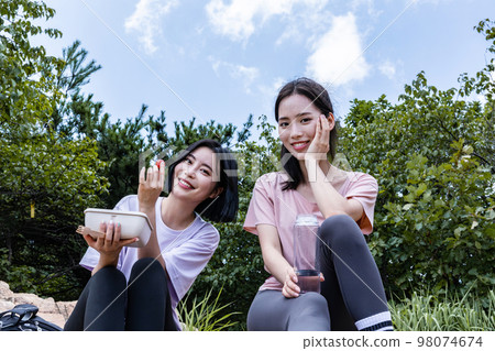 korean young women hiking and plogging_eating water and lunch box 98074674