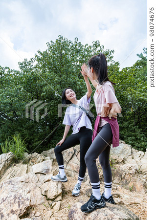 korean young women hiking and plogging_facing each other cheering hand motion korean young women hiking and plogging_facing each other cheering hand motion 98074676