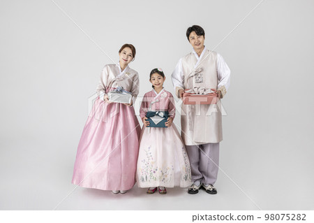 Korean family in Hanbok, isolated white background_holding a presents Korean family in Hanbok, isolated white background_holding a presents 98075282