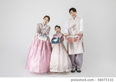 Korean family in Hanbok, isolated white background_holding a presents 98075310