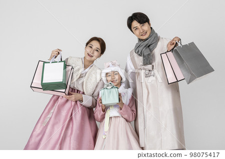 Korean family in Hanbok, isolated white background_holding a shopping bags and presents Korean family in Hanbok, isolated white background_holding a shopping bags and presents 98075417