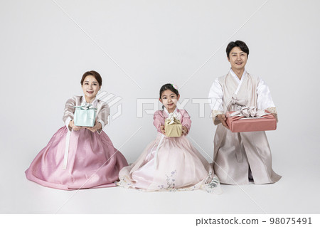 Korean family in Hanbok, isolated white background_holding a presents 98075491