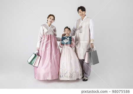 Korean family in Hanbok, isolated white background_holding a shopping bags and presents Korean family in Hanbok, isolated white background_holding a shopping bags and presents 98075586